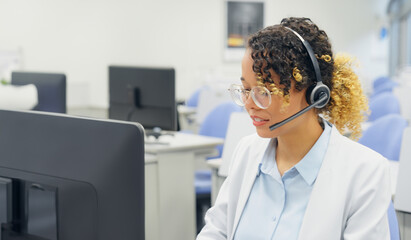 A black female operator is answering the phone at a call center.