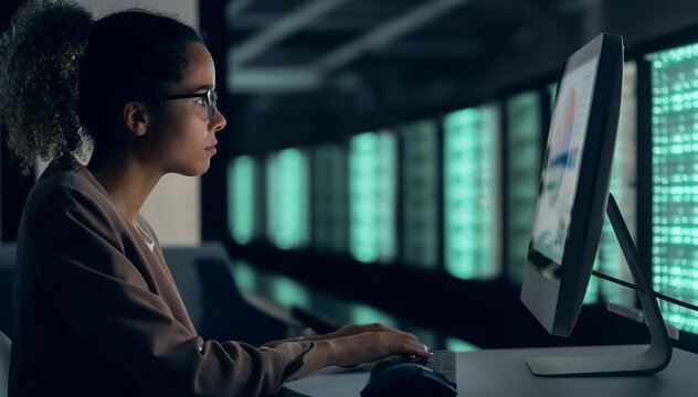 black female engineer working in server room.