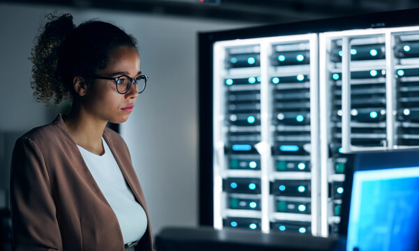 black female engineer working in server room.