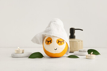 Fototapeta Pumpkin with mask, spa stones and leaves on light background obraz