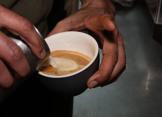 Barista Pouring Milk Into A Coffee