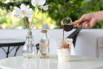 person pouring coffee into glass