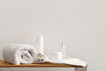 Fototapeta na wymiar Set of spa supplies on table near white wall