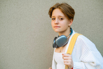 schoolgirl with headphones and striking yellow backpack personifies energy and modern lifestyle