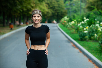 Athletic young woman in sportswear jogging in the park. Fitness and healthy lifestyle. Portrait of a beautiful young woman in sportswear outdoors. Sport fitness model caucasian ethnicity training.