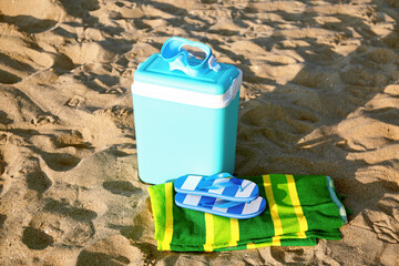 Beach cooler and accessories on sand