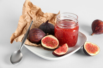 Jar of sweet fig jam on white background