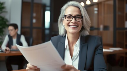 Happy Mid Aged Businesswoman Holding Paper Document at Job Interview - Corporate Office Meeting, Smiling Professional Banking Manager or Lawyer, Consulting, Sitting at Work, CV