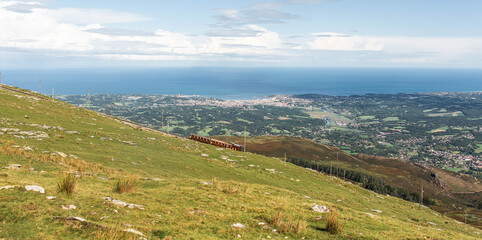 Fototapeta na wymiar Magnificent panorama of the Rhune in the French Basque Country and its famous typical train with a view of the Bay of Saint-Jean-de-Luz