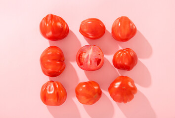 Fresh ripe tomatoes on pink background