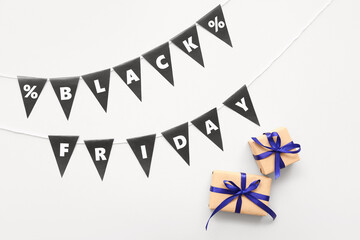 Obraz premium Gift boxes, rope, flags with text BLACK FRIDAY and percent signs on white background