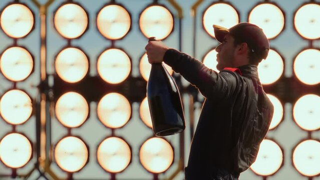 Racing driver pilot celebrates a win in a championship, standing on a podium