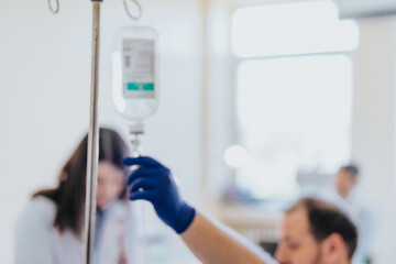 Experienced Specialist Conducting Medical Infusion Therapy for Patient in Hospital Room