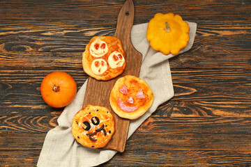 Obraz na płótnie Canvas Board with different tasty Halloween mini pizzas on wooden background