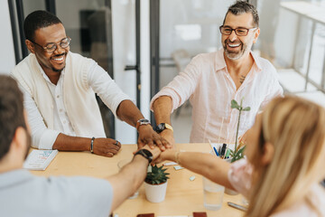 Successful employees putting hands together.