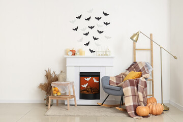 Interior of living room decorated for Halloween with fireplace, rocking chair and paper bats