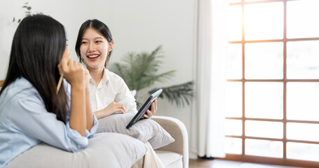 Happy business colleagues having casual discussion over tablet pc at home office.