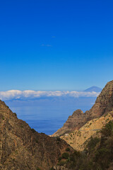 View of Teide from La Gomera. The silhouette of the highest peak in Spain stands out on the horizon, framed between the vertical walls of a deep ravine