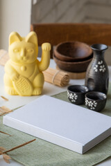 Book mockup design. Blank white book on dining table in asian style with tableware