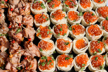 Snacks and canapes and tartlets stuffed in the assortment on the buffet table. The food is varied and appetizing for a banquet.
