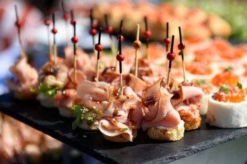 Snacks and canapes and tartlets stuffed in the assortment on the buffet table. The food is varied and appetizing for a banquet.