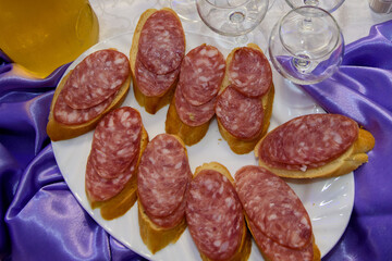 Sandwiches with smoked sausage. The food is varied and appetizing for a banquet.