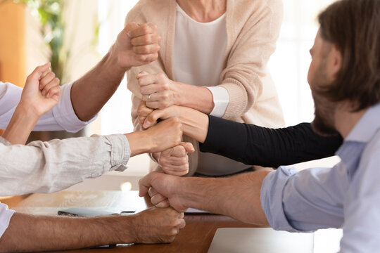 Group of businesspeople stack fists making tower enjoy engagement in funny team building activity, stronger together, cooperation and support, every link in chain is equally important business concept