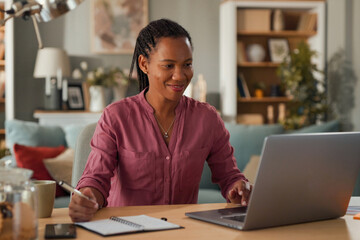 African American woman working on laptop at home office