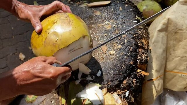 Peel the young coconut using a machete knife.