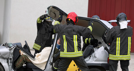 firefighters during rescue of the injured after the car accident with the stretcher to transport...