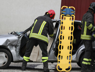 firefighters during rescue of the injured after the car accident with the stretcher to transport...