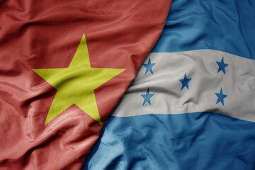 big waving realistic national colorful flag of vietnam and national flag of honduras .