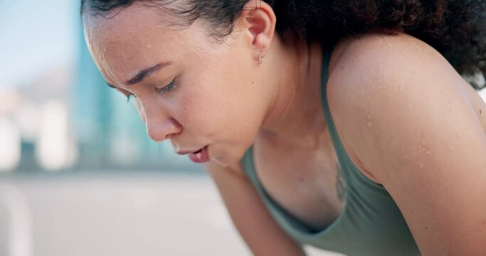 Fitness, breathe and tired woman in the city for running, marathon or competition training. Sports, rest and young female athlete runner sweating with fatigue on a break for cardio workout in town