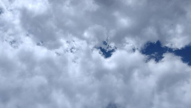 Landscape in the sky with two very large clouds moving in unison at noon