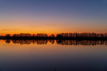 beautiful orange-yellow sunset on the lake in spring