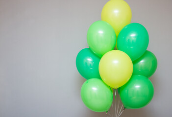 a bunch of green and light green balloons with helium on a white background, birthday