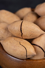 unpeeled pecans in a shell on the kitchen table, close up