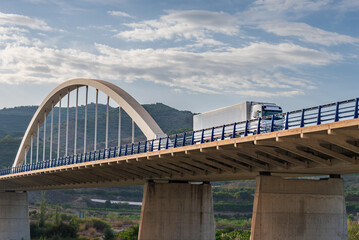 Refrigerator truck traveling on a highway on a suspension bridge, low angle view or nadir.