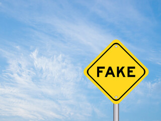 Yellow transportation sign with word fake on blue color sky background