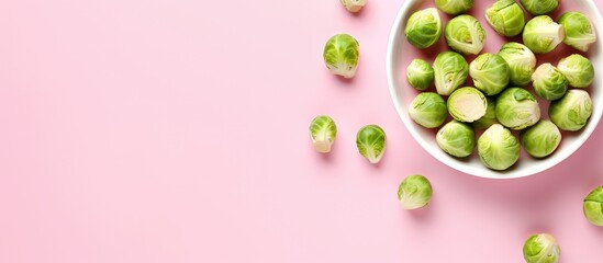 Fresh Brussels sprouts on a isolated pastel background Copy space from above - obrazy, fototapety, plakaty