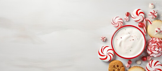 Homemade cookies topped with cream and candy cane on a isolated pastel background Copy space - obrazy, fototapety, plakaty