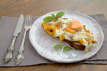 open sandwich with egg and yellow tomato