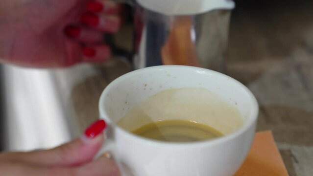 The process of pouring whipped milk into coffee to make a cappuccino