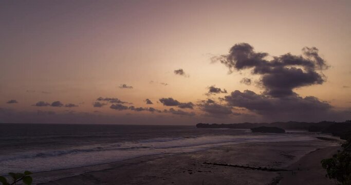 Timelapse of colorful sky after sunset with clouds rolling over the beach