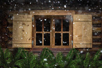 Holzfenster mit Tannenzweigen als Dekoration und Schneeflocken