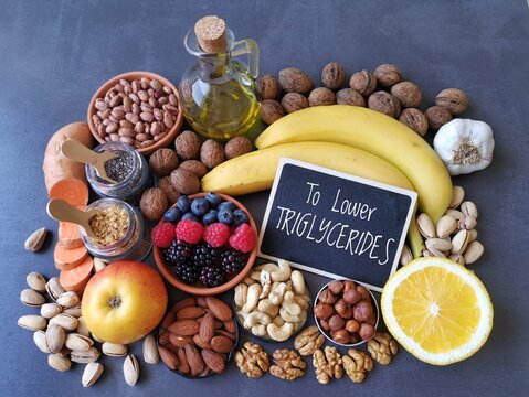 Foods to lower triglycerides. Healthy food products to reduce triglyceride levels. High triglycerides diet concept. Berries, nuts, olive oil, apple, banana, garlic, sweet potato, chia seed, soy, beans
