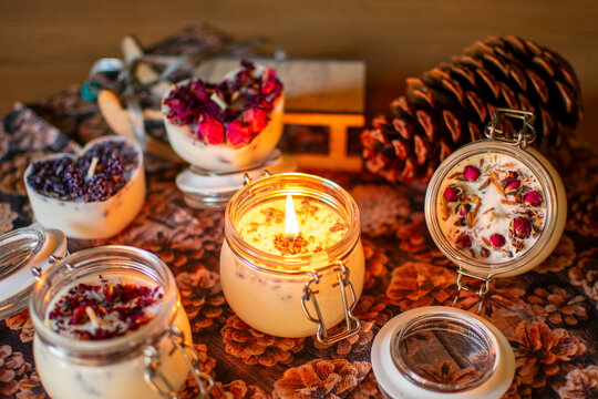 Weihnachtliche Stimmung mit brennender Kerze im Glas mit Lavendel oder Rosenblüten.