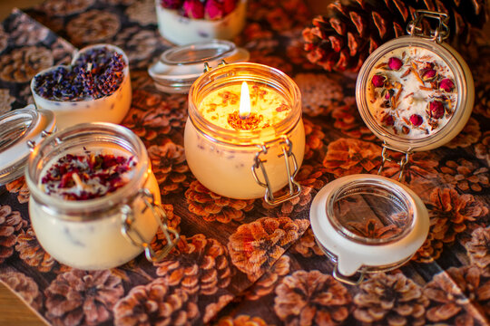 Brennender Kerze im Glas mit Lavendel oder Rosenblüten.