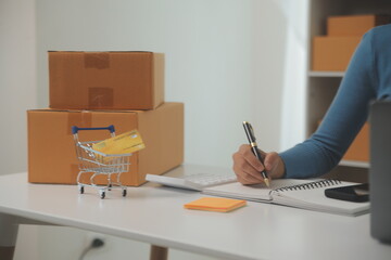 Business woman start up small business entrepreneur SME success .freelance woman working at home with Online Parcel delivery. SME and packaging deliveryconcept