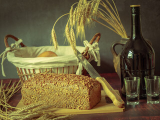 Rustic still life in antique style with bread and ears of wheat . - 651622065